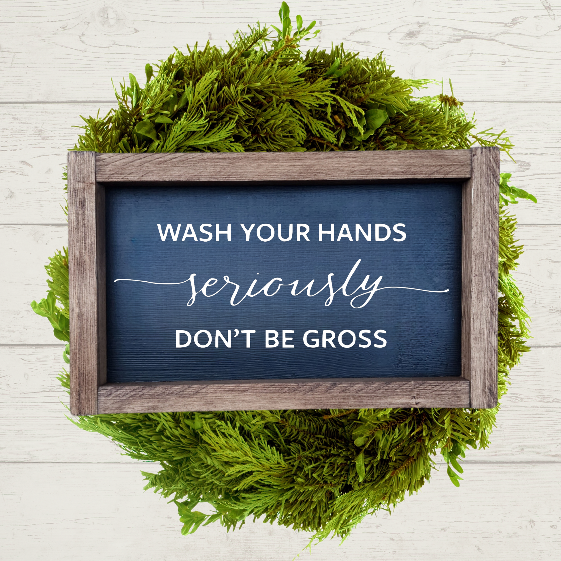White text that says wash your hands, seriously, don't be gross with a black background and brown stained frame in a 5x9 size.
